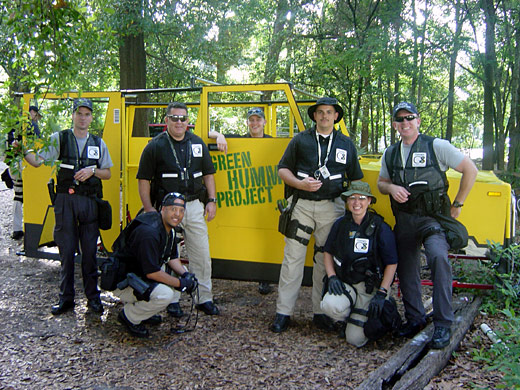 Police officers in tactical vests posing in front of the Green Hummer
