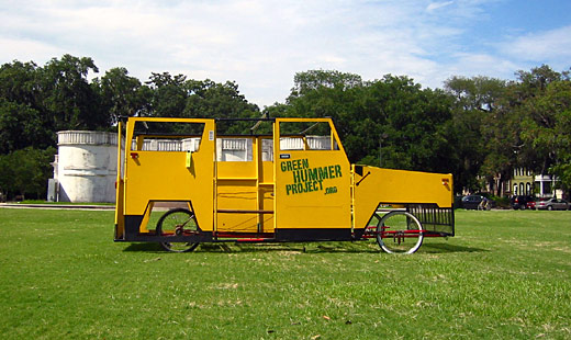 The Green Hummer in profile on a grassy field