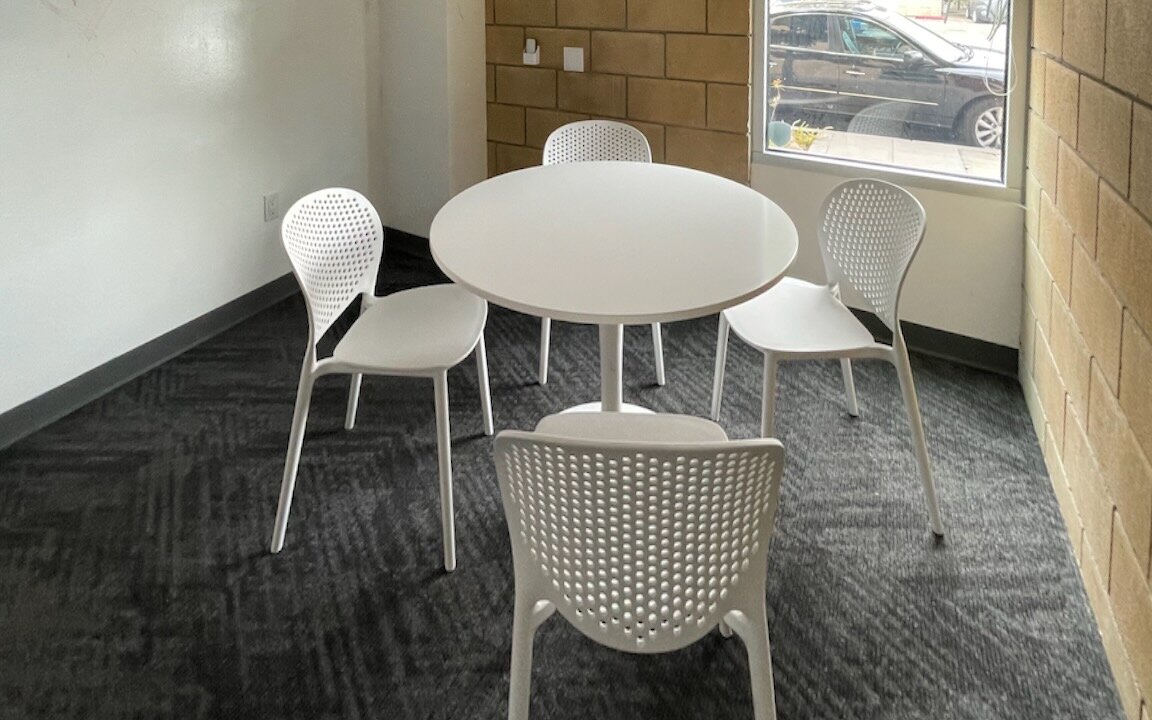 The conference room, with a round white table and four white chairs