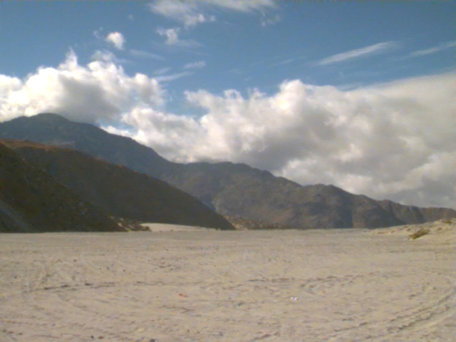 Mountains and clouds over a sandy plain