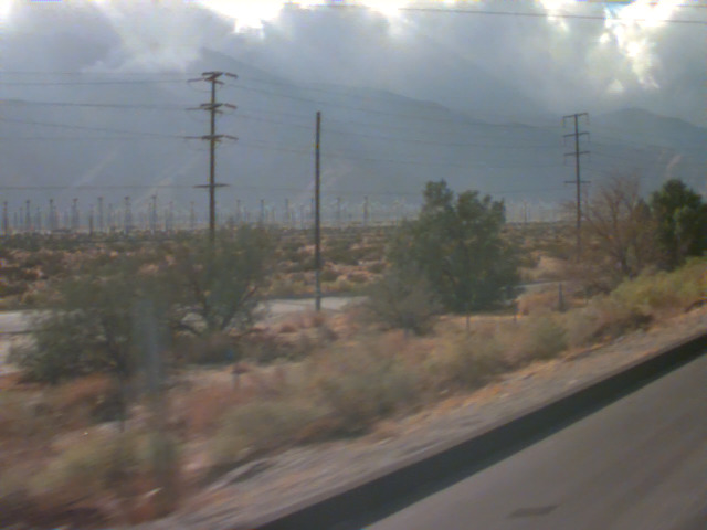 Desert scrub and power lines under a cloudy sky
